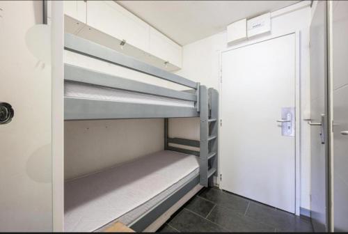 a room with two bunk beds and a door at APT confortable centre station face aux pistes de Val Thorens in Val Thorens