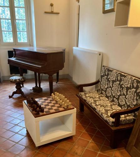a living room with a piano and a chess board at Cottage authentique et chaleureux entre Pau et Lourdes pour 7 personnes in Nousty