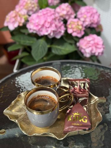 two cups of coffee on a glass table with flowers at Privatni apartman u vili ,privatni bazen, privatni wellness - jacuzzi, finska sauna in Črnec Biškupečki