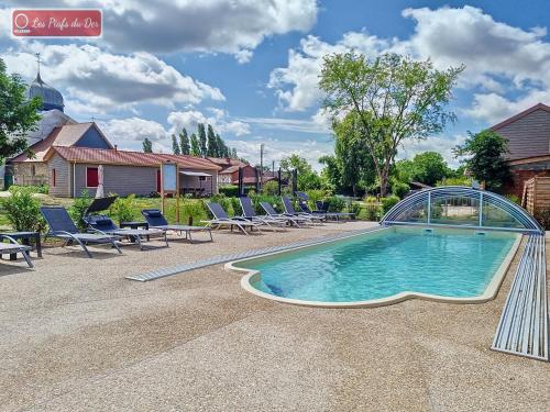 une piscine avec des chaises longues et une piscine dans l'établissement Les Piafs du Der 2, à Joncreuil