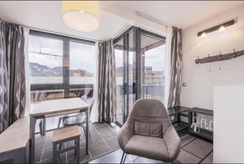 a room with a chair and a desk and window at APT confortable centre station face aux pistes de Val Thorens in Val Thorens