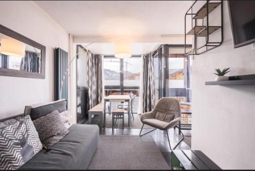 a living room with a couch and a chair and a table at APT confortable centre station face aux pistes de Val Thorens in Val Thorens
