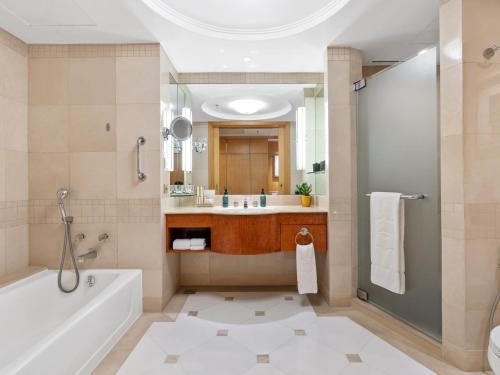 a bathroom with a tub and a sink at Makati Shangri-La, Manila in Manila