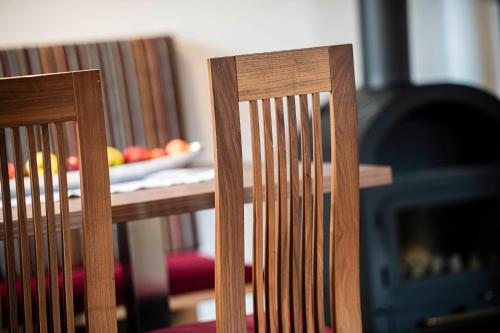 two wooden chairs in front of a fire place at Moarhof Albeins in Albes