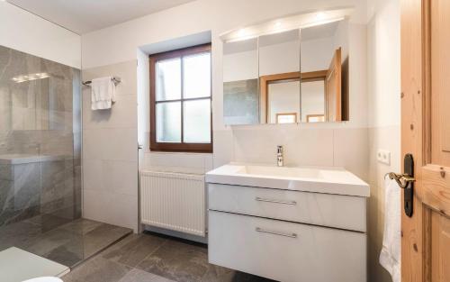 a white bathroom with a sink and a shower at Moarhof Albeins in Albes
