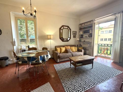un salon avec une table et un canapé dans l'établissement ApartHotel Riviera - BALCON HONORE 1 - Old Town - 5 mn Promenade des Anglais et Plage - Charme Absolu - Appartement 2 pièces avec Balcon AC - Vue mer et Ville, à Nice