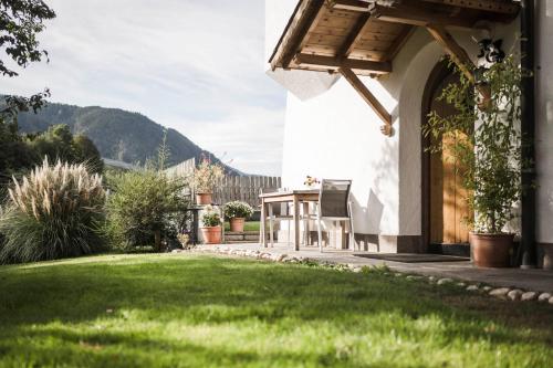 a house with a lawn and a chair in a yard at Moarhof Albeins in Albes