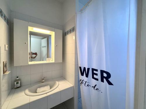 une salle de bain avec toilettes et rideau de douche dans l'établissement ApartHotel Riviera - BALCON HONORE 1 - Old Town - 5 mn Promenade des Anglais et Plage - Charme Absolu - Appartement 2 pièces avec Balcon AC - Vue mer et Ville, à Nice