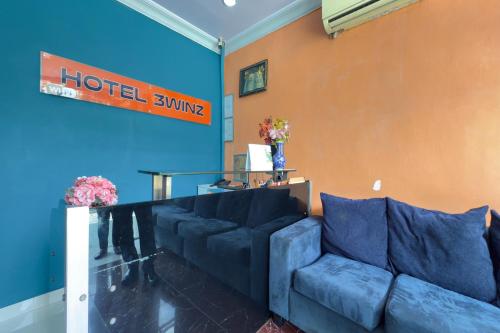 a living room with a blue couch in a hotel room at Hotel 3Winz, Chow Kit Hospital Kuala Lumpur in Kuala Lumpur