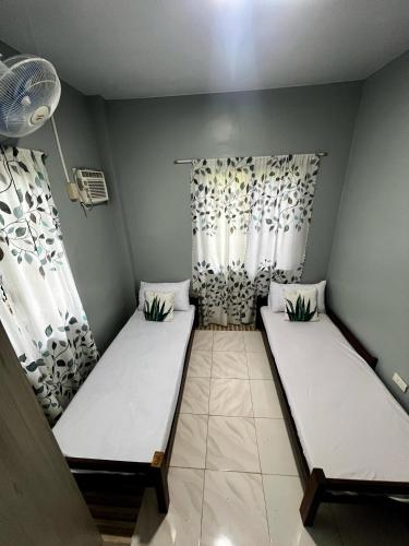 two beds in a small room with curtains at Publikhaus in Caliclic