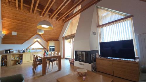 a living room with a large television and a table at Komforna planinska kuća za odmor in Mrkopalj