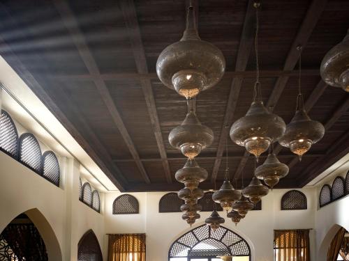 a row of lights hanging from a ceiling at Aldhafra Desert Resort, Vignette Collection by IHG in Madīnat Zāyid