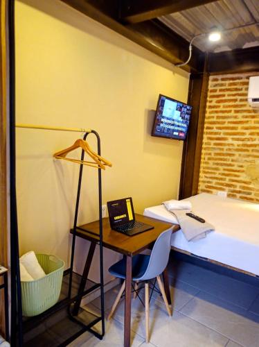 a room with a desk and a bed with a laptop at Habitación privada en Getsemaní in Cartagena de Indias