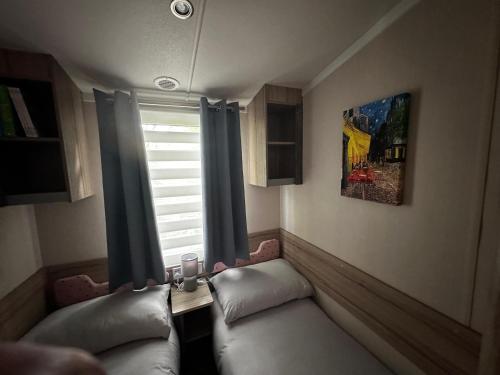 a living room with a couch and a window at Tranquil Caravan Retreat by the Seaside PortSeton in Prestonpans