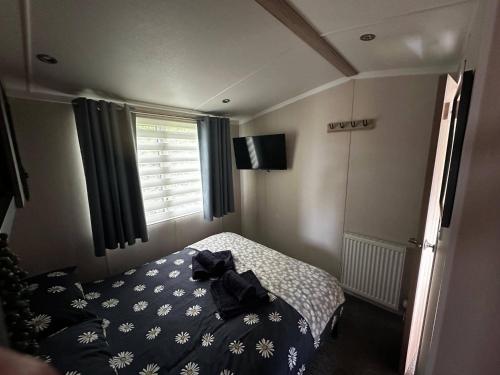 a bedroom with a bed with a shirt on it at Tranquil Caravan Retreat by the Seaside PortSeton in Prestonpans