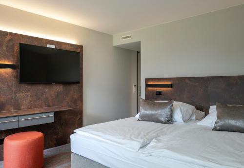 a hotel room with a bed with a flat screen tv at Hotel Metropole Interlaken in Interlaken