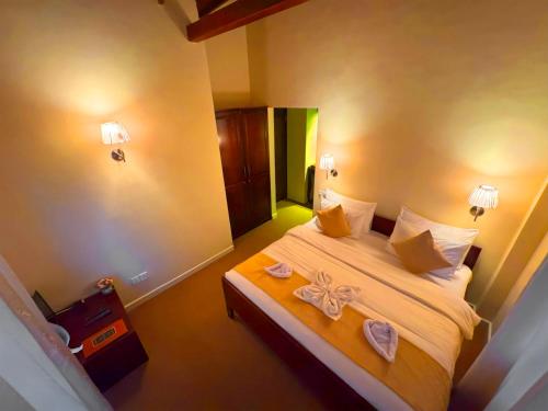 a bedroom with a bed with a flower on it at The Tapherini Bungalow in Nuwara Eliya
