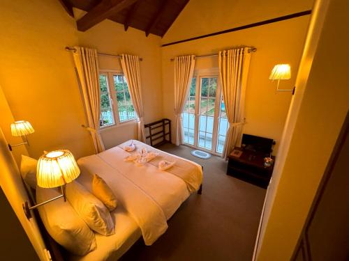 a bedroom with a bed with two towels on it at The Tapherini Bungalow in Nuwara Eliya