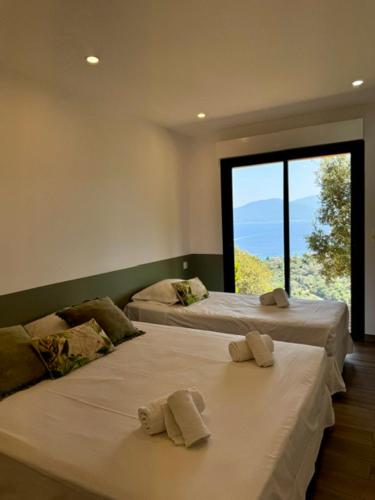 deux lits dans une chambre avec des serviettes dessus dans l'établissement Somptueuse villa d’architecte avec vue mer, à Belvédère