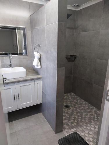 a bathroom with a sink and a shower at Velddrif Riverside Guesthouse in Velddrif