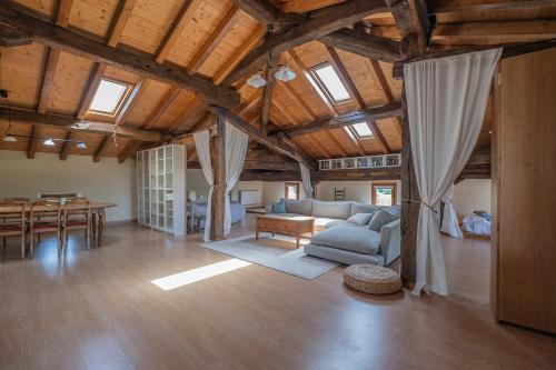 a large living room with a couch and a table at Biendella El Desván 
