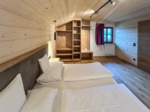two beds in a room with wooden floors at Madlhof in Himmelreich