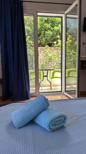 a blue towel laying on a bed in front of a window at Filoxenia Residence in Palasë