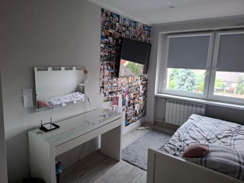a bedroom with a desk and a mirror and a bed at Pokoje do wynajęcia in Michałowo