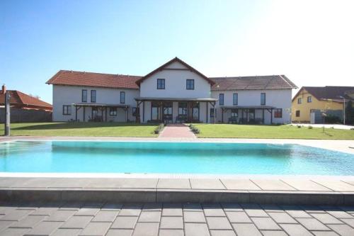 a large swimming pool in front of a house at Penzion Vlaštovka in Dolní Dunajovice