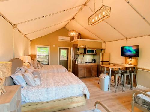 ein Schlafzimmer mit einem großen Bett in einem Zelt in der Unterkunft Beautiful Tented Cabin by a Creek - Ideal for a Fun Family Vacation in Seguin, Texas in Lauback
