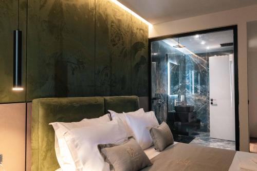 una camera da letto con un letto con una parete verde di Cuni Luxury Hotel a Sarandë
