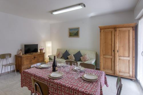 a dining room with a table and a couch at Dolomiapartments - Appartamento CENTRALE in Predazzo