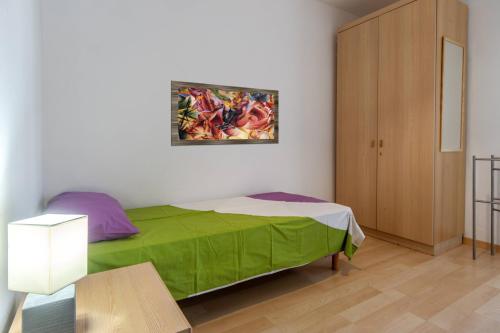 a bedroom with a bed with a painting on the wall at Dolomiapartments - Appartamento CENTRALE in Predazzo