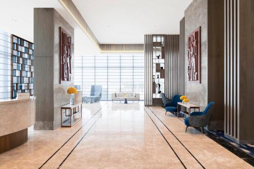 a lobby with couches and chairs in a building at Crowne Plaza Lucknow by IHG in Lucknow