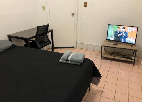 Private 2-bedroom apartment and New York City Manhattan only 15 mins away في يونيون سيتي: غرفة نوم بسرير وطاولة مع تلفزيون