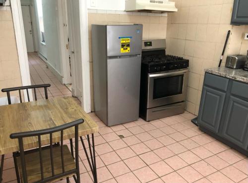 Private 2-bedroom apartment and New York City Manhattan only 15 mins away في يونيون سيتي: مطبخ مع ثلاجة وطاولة مع كراسي