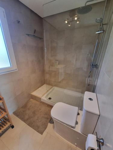 a bathroom with a shower and a toilet and a tub at Beautiful views lake golf house in Roldán