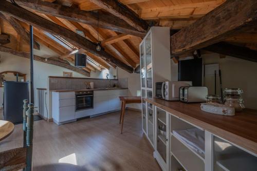 a large kitchen with wooden ceilings and wooden floors at Biendella El Desván 