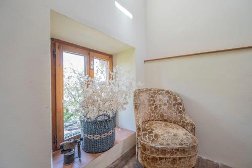 a chair sitting in a room with a window at Biendella El Desván 