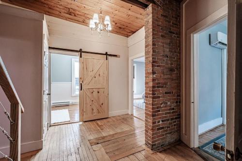 an open hallway with a brick wall and a door at Lofty Ambition - Stunning West End Rooftop Retreat in Portland