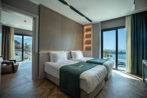 a bedroom with a large bed with a large window at Shayna Beach Club in Kérynia