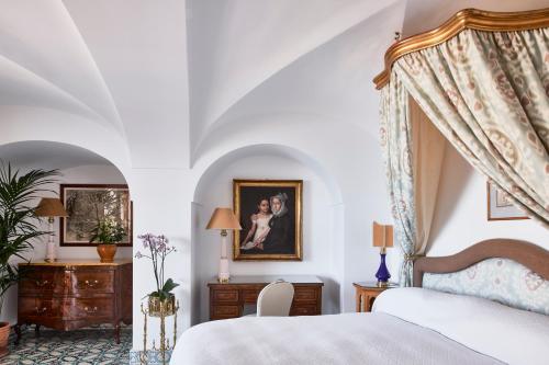 a bedroom with a canopy bed and a dresser at Le Sirenuse in Positano