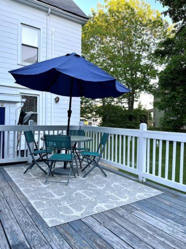 a table and chairs with an umbrella on a deck at Arlies Digs One Block To Willard Beach in South Portland