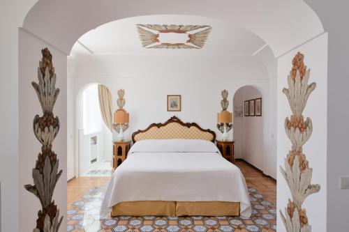 a bedroom with a bed in a white room at Le Sirenuse in Positano