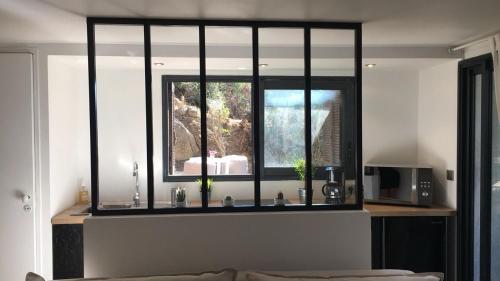 a living room with a window and a microwave at Beau Studio au pied de la Cidatelle in Porto-Vecchio