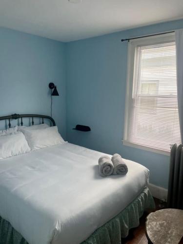 a bedroom with a bed with two towels on it at Beautiful West End Apartment in Portland