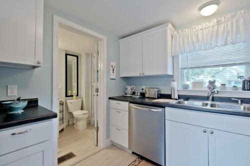 a kitchen with white cabinets and a sink and a toilet at Back Cove - Large Sunny 2 Bedroom Condo in Portland