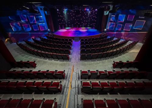 an empty auditorium with red seats and a stage at Crowne Plaza Resort Guam in Tumon