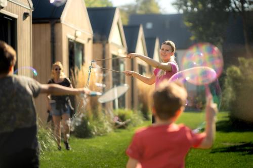 un gruppo di bambini che giocano con l'hula in un cortile di Pod Cyprysami - surf & family resort a Jastarnia