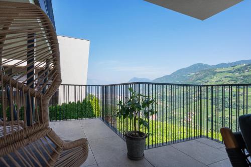 a rattan chair sitting on a balcony with a view at New Opening Vinea Guesthouse in Cornedo all'Isarco